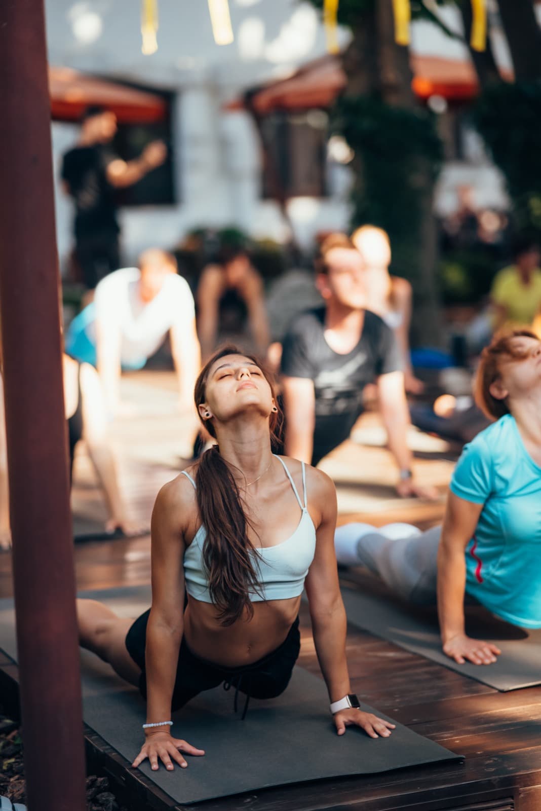 Frau übt mit ihrer Gruppe Yoga im Freien